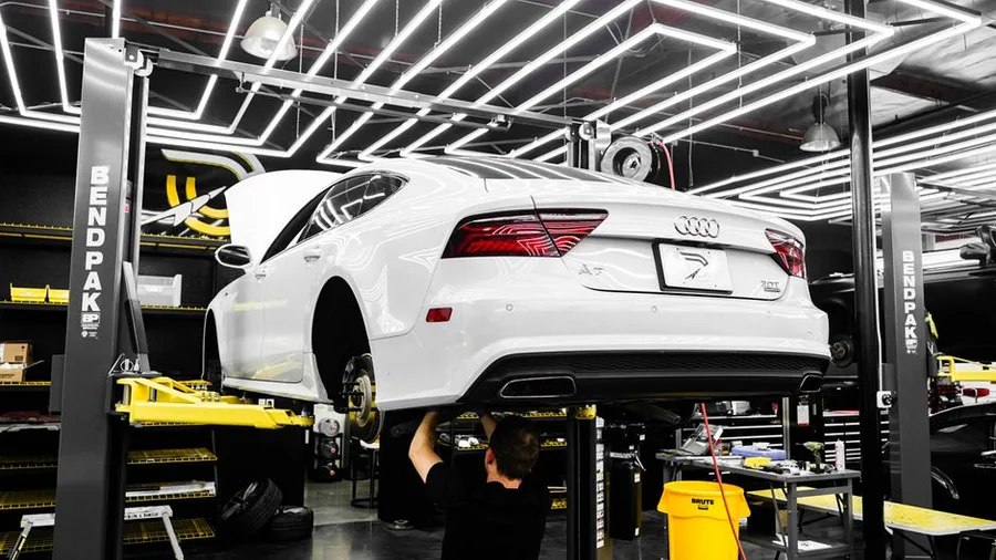 A car up on the lift with the wheels off for suspension work